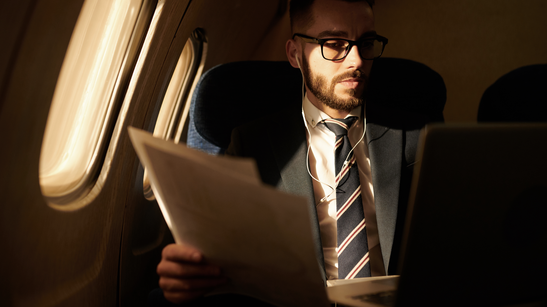 Men in airplane working on corporate travel industry